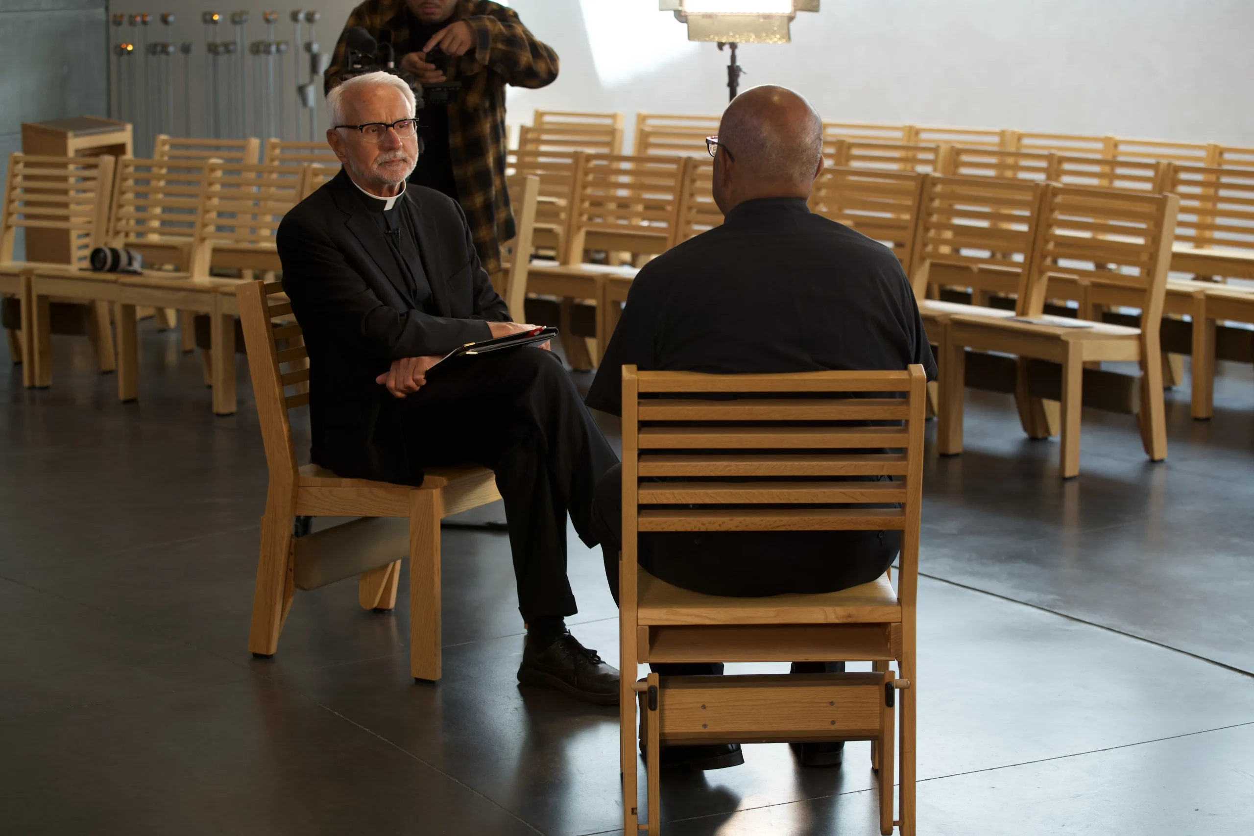 Two priests in conversation in a quiet chapel